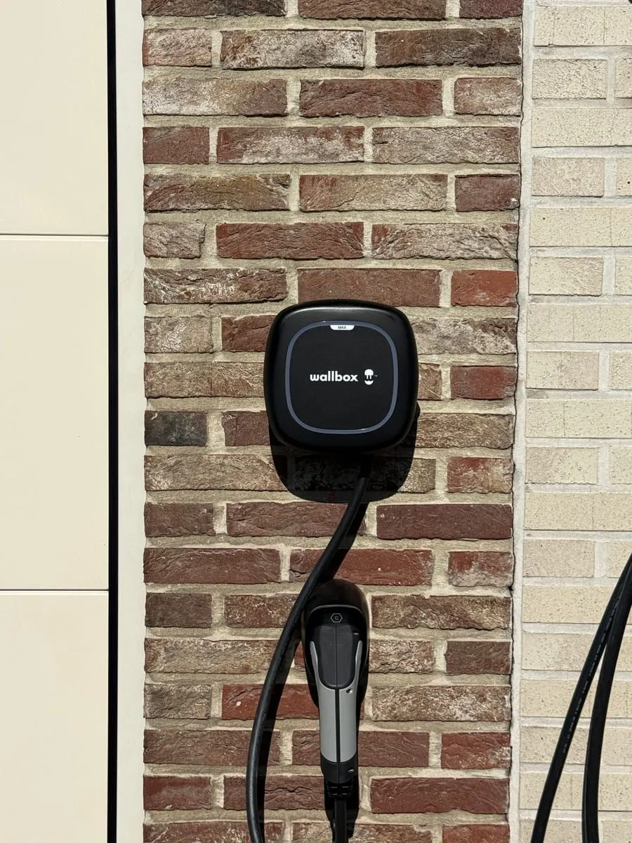 Wallbox Pulsar Max thuislaadpaal met Type 2-connector geinstalleerd op een bakstenen gevel door BORNEXA